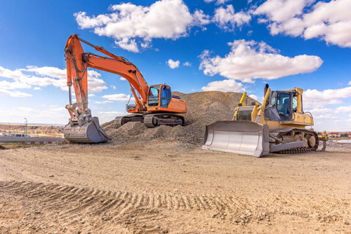 An excavator and bulldozer working together at a construction site