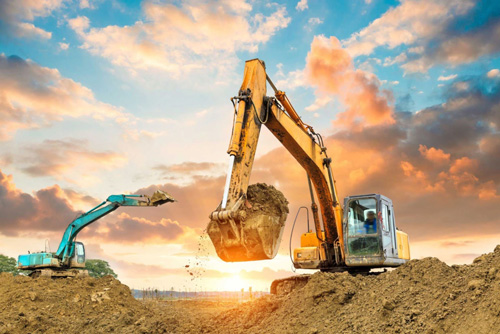 Two excavators digging a trench outside